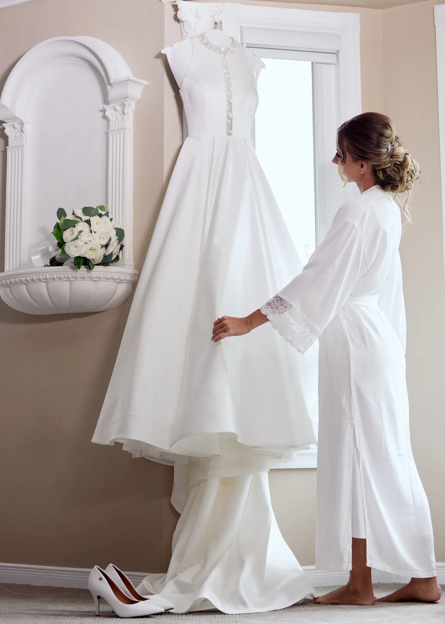 Novia preparándose junto a su vestido de Nika Bridal